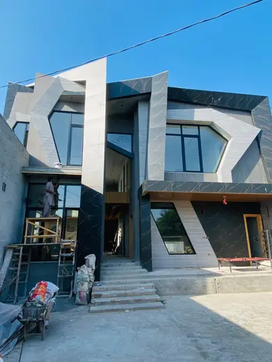 Modern home facade with scaffolding and workers