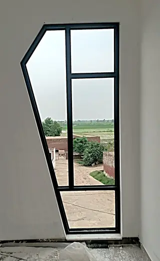 Tall custom-shaped aluminium window with black frame