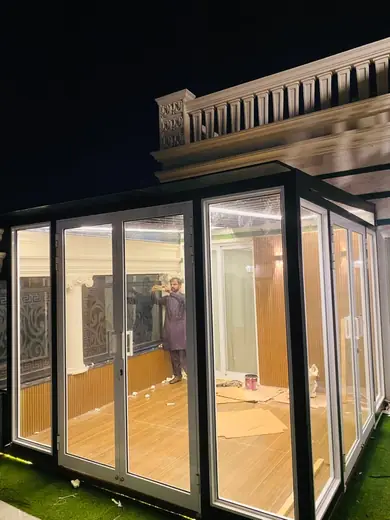 Terrace glass room at night with white aluminium frames
