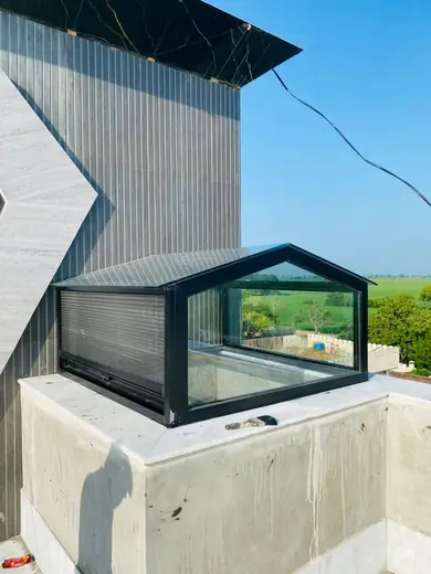 Black frame glass skylight beside a modern facade